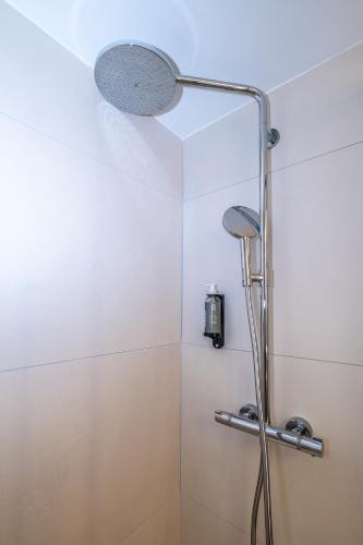 a shower with a shower head in a bathroom at Hôtel Le Relais des Brasseurs - Aubagne in Aubagne