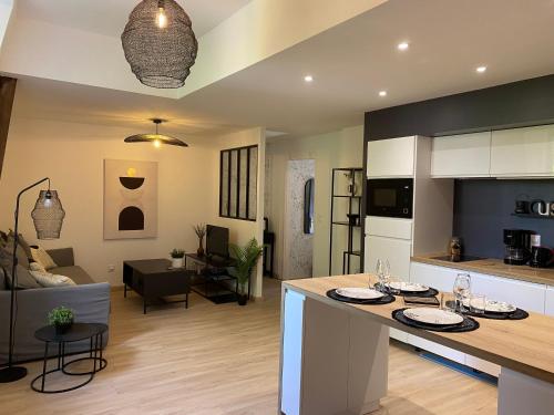 une cuisine et un salon avec un îlot dans la cuisine dans l'établissement L'atelier d'Arches, à Charleville-Mézières