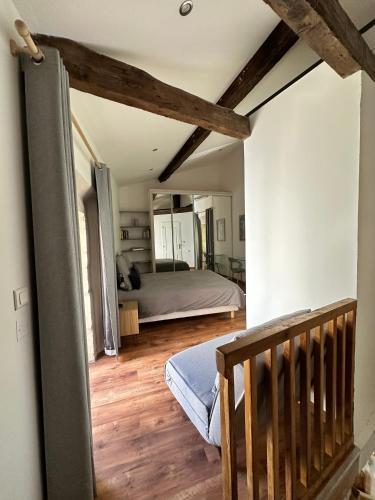 - une chambre avec un lit et un escalier en bois dans l'établissement Maison Arenas, à Arles