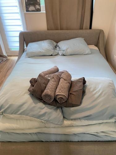 a bed with two rolled towels on it at Appartement proche La Villette avec 2 balcons in Pantin