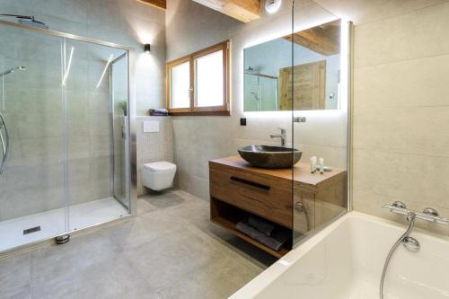 une salle de bain avec une baignoire, un lavabo et une douche dans l'établissement Résidence L'eclat Des Cimes - Chalet L'Eclat des Cimes - 12 Personnes - Morzine MAE-1921, à Morzine