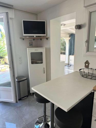 Il comprend une cuisine avec une table blanche et une télévision murale. dans l'établissement Résidence Rayolet - Super appart au calme au brusc et plages à 300m MAE-9794, à Six-Fours-les-Plages