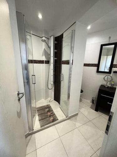 La salle de bains est pourvue d'une douche en verre et de carrelage. dans l'établissement Résidence Rayolet - Super appart au calme au brusc et plages à 300m MAE-9794, à Six-Fours-les-Plages