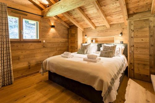une chambre avec un lit dans une cabane en rondins dans l'établissement Résidence Mignette - Chalet Mignette - 8 Personnes - Morzine MAE-1931, à Morzine