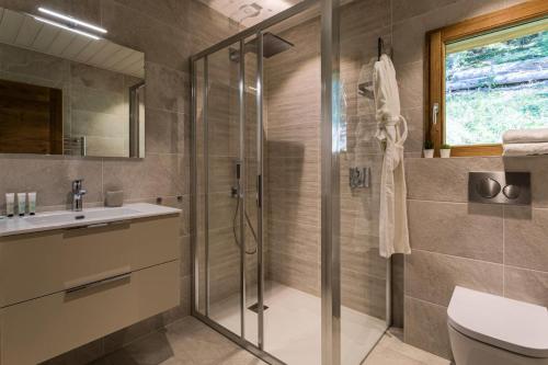 une salle de bain avec une douche, des toilettes et un lavabo dans l'établissement Résidence Mignette - Chalet Mignette - 8 Personnes - Morzine MAE-1931, à Morzine