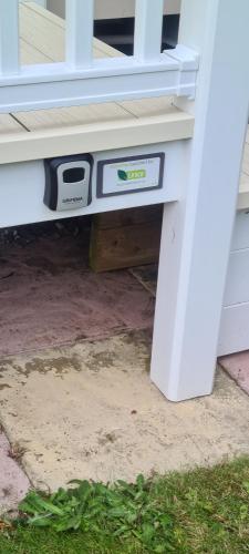 a white bench with an electrical box under it at Deluxe 3 Bed Holiday Home in Port Seton in Port Seton
