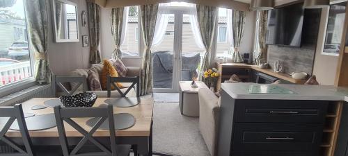 a kitchen and living room with a table and chairs at Deluxe 3 Bed Holiday Home in Port Seton in Port Seton