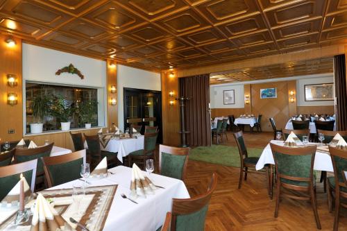 a dining room with white tables and chairs at Landgasthaus Hotel H. Kortlüke in Belm