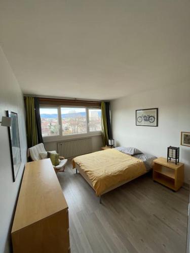 une chambre avec un lit et une grande fenêtre dans l'établissement Geneva Residences - Cozy apartment close to UN, à Ferney-Voltaire