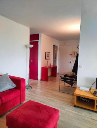 un salon avec un canapé rouge et une table dans l'établissement Geneva Residences - Cozy apartment close to UN, à Ferney-Voltaire