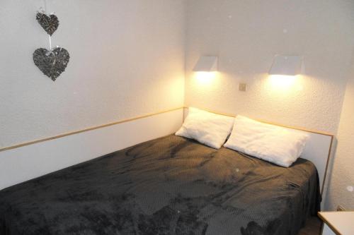 - une chambre dotée d'un lit avec deux oreillers et d'un cœur sur le mur dans l'établissement Résidence Callisto - 2 Pièces pour 5 Personnes 524, à Mâcot La Plagne