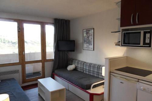 - un petit salon avec un canapé et une fenêtre dans l'établissement Résidence Callisto - 2 Pièces pour 5 Personnes 524, à Mâcot La Plagne