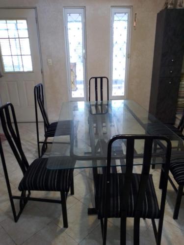 a glass table and chairs in a living room at Guantánamo in Mérida
