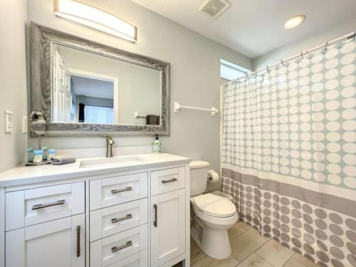 a bathroom with a toilet and a sink and a mirror at Sunshine Cove in Haines City
