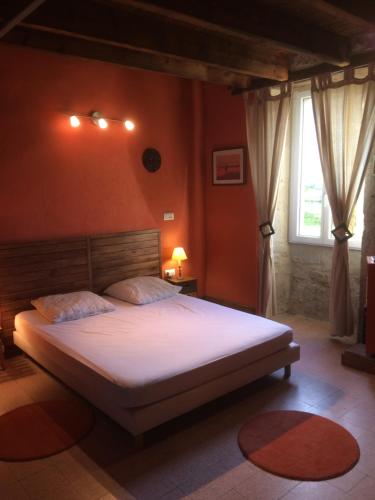 une chambre avec un grand lit avec des draps blancs dans l'établissement Gîte à la ferme en Bas Quercy, à Durfort