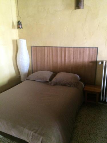 Cette chambre comprend un lit avec deux oreillers et une lampe. dans l'établissement Gîte à la ferme en Bas Quercy, à Durfort