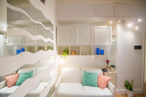 a living room with a white couch with colorful pillows at Il Gigliolo Apartment in Florence