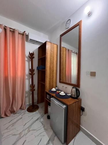 a bathroom with a television and a mirror on the wall at Nungwi Beach Front in Nungwi
