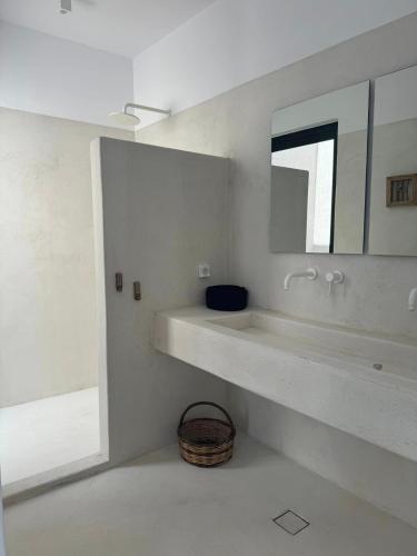 a white bathroom with a sink and a mirror at GR - Villa La Punta Mikri in Plaka