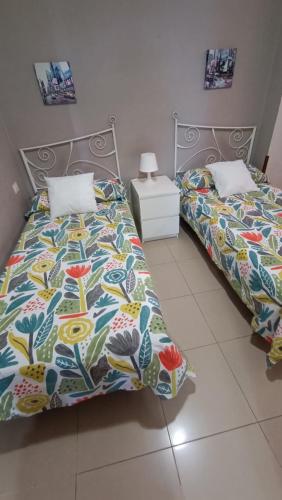 two beds sitting next to each other in a bedroom at Apartamento Candelaria vivienda vacacional in Candelaria