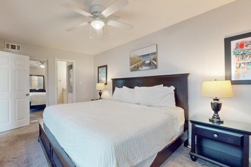 Un dormitorio con una cama y un ventilador de techo. en Tradewinds 07, en Destin