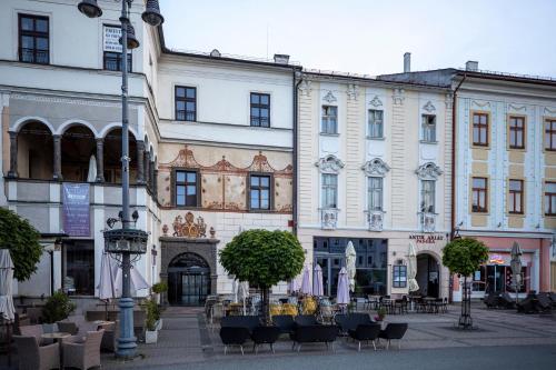 a group of buildings with tables and chairs in a street at ALURE RESIDENCES 11 - 24h self check-in & private parking next to the apartment building included, CITY CENTER right on SNP Square in a quiet passage, new building, best deal in town in Banská Bystrica