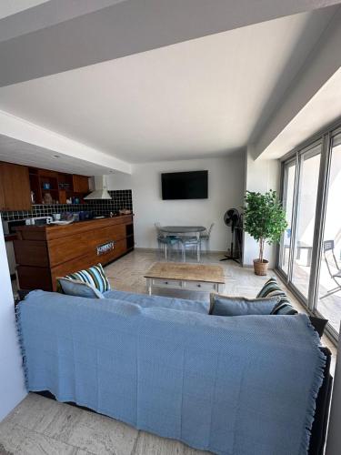 un salon avec un canapé bleu et une table dans l'établissement Appartement vue mer Sainte Maxime, à Sainte-Maxime