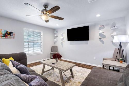 a living room with a couch and a flat screen tv at The shoe LA-LA house in San Antonio