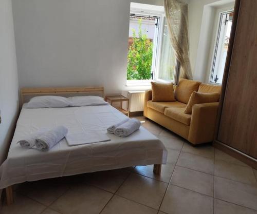 a bedroom with a bed and a couch at Filip and Myrsinis house - apartment in Ayios Nikolaos Sithonia