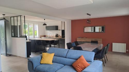 un salon avec un canapé bleu et une cuisine dans l'établissement Grande Maison au calme à 5mn de la plage, à Moëlan-sur-Mer