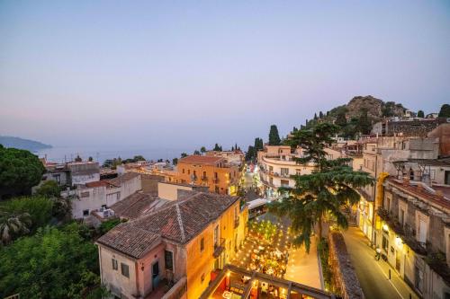 an aerial view of a city at night at La Terrazza di Porta Messina in Taormina