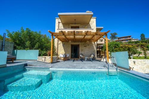 a villa with a swimming pool and a house at Asion Lithos in Kato Asites