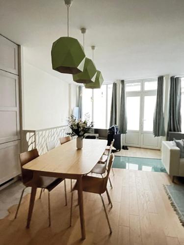 un salon avec une table et une salle à manger dans l'établissement Charming family loft near the Parc de Belleville, à Paris