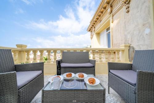 une terrasse avec des chaises et une table avec de la nourriture. dans l'établissement Villa Monique - Le Luxe proche de la mer, à Nice