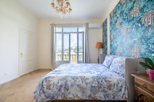 une chambre avec un lit et une grande fenêtre dans l'établissement Villa Monique - Le Luxe proche de la mer, à Nice