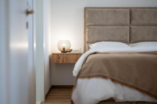 a bedroom with a bed and a lamp on a night stand at Lush Suites in Trogir