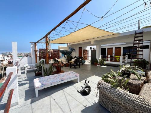 a patio with couches and plants on a building at Bravo Hostels: Surf House in Punta Hermosa