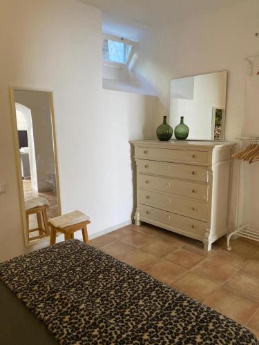 a bedroom with a dresser with two green vases on it at Starman in Cazorla