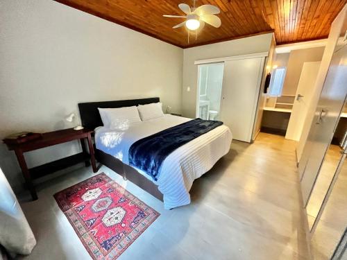 a bedroom with a bed with a ceiling fan and a rug at Thornhill Tranquility in Pretoria