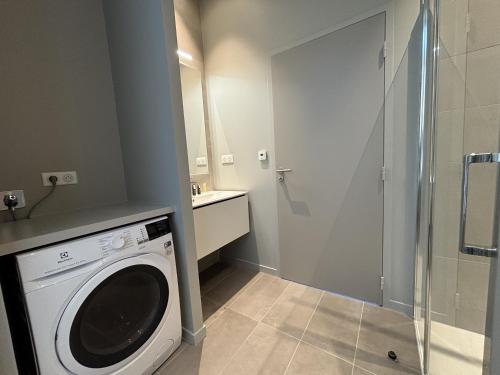 une machine à laver dans une salle de bain avec douche dans l'établissement Brehat T3, sea view, à Trébeurden