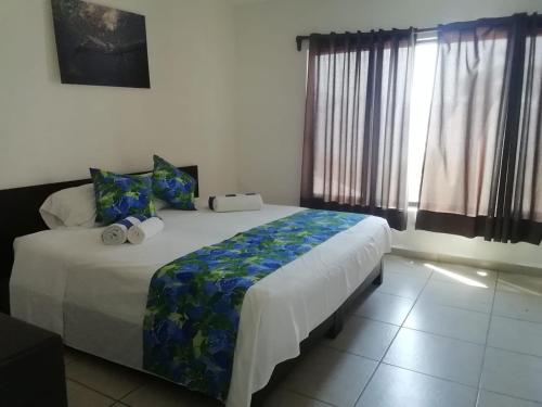 a bedroom with a large bed and a window at Casa Las iguanas in Acapulco