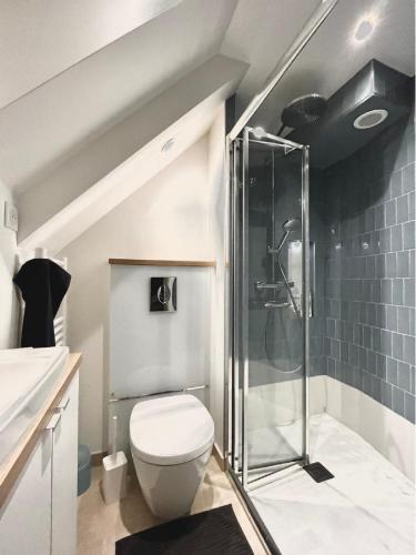 une salle de bain avec toilettes et douche en verre dans l'établissement Charming family loft near the Parc de Belleville, à Paris