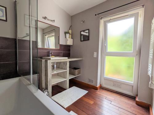 ein Badezimmer mit Waschbecken und Dusche und einem Fenster in der Unterkunft Charmante Maison en pleine nature avec piscine in Assas