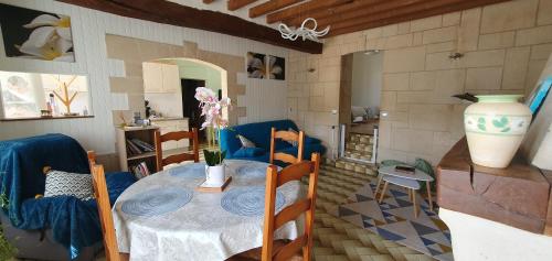 a dining room with a table and a vase at La Maison du Druide in Bonneuil-en-Valois