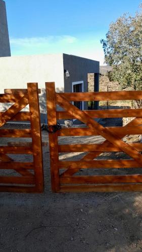 ein Holztor vor einem Haus in der Unterkunft Casa Safari en La Paisanita, Alta Gracia in Alta Gracia