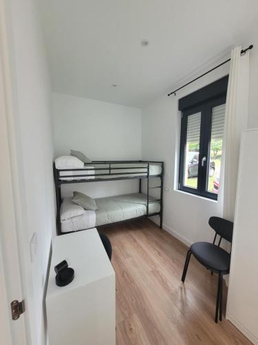 a small room with a bunk bed and a desk at Génesis Valdoviño in Valdoviño