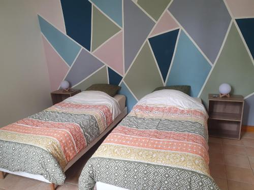 two beds sitting next to each other in a bedroom at La Maison du Druide in Bonneuil-en-Valois