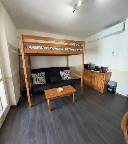 - un salon avec un canapé et des lits superposés dans l'établissement La petite Maison de TITI, à Borgo