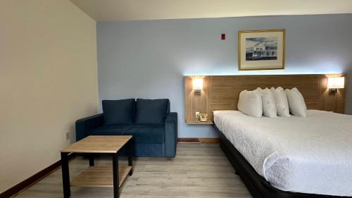 a hotel room with a bed and a blue chair at USA Inn in Wells