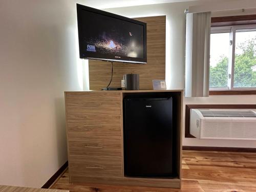 a flat screen tv sitting on top of a wooden entertainment center at USA Inn in Wells
